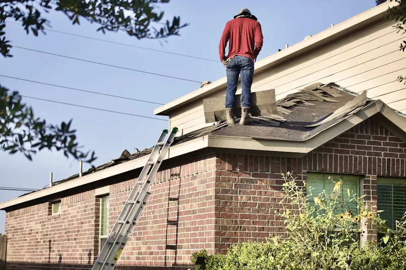 Professional roofer working on a residential roof in Stratford